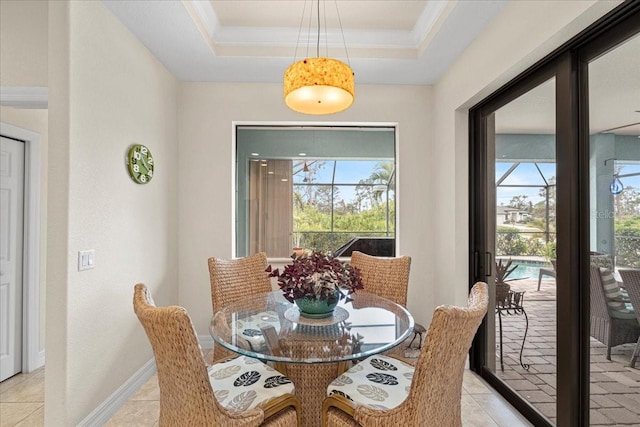 dining area with crown molding, a healthy amount of sunlight, and a raised ceiling