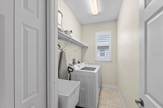 laundry room with separate washer and dryer, sink, and light tile patterned flooring