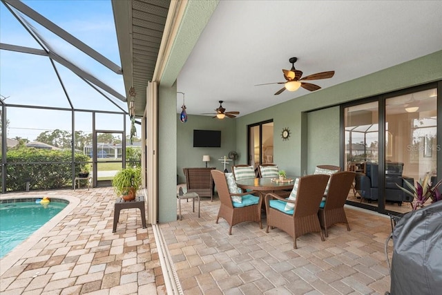 view of patio with ceiling fan and glass enclosure