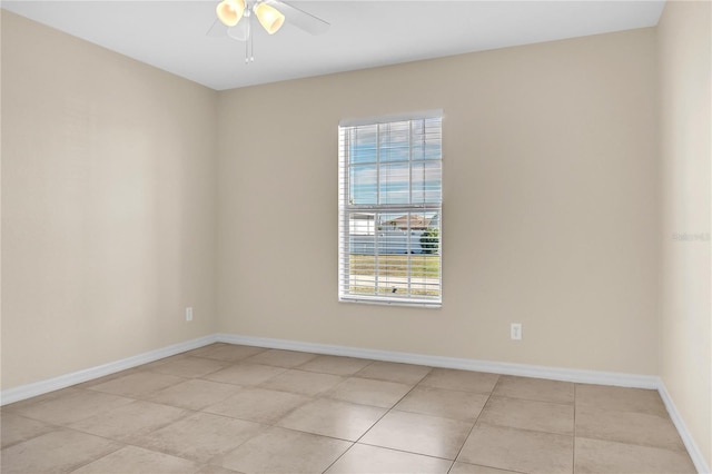 tiled spare room featuring ceiling fan