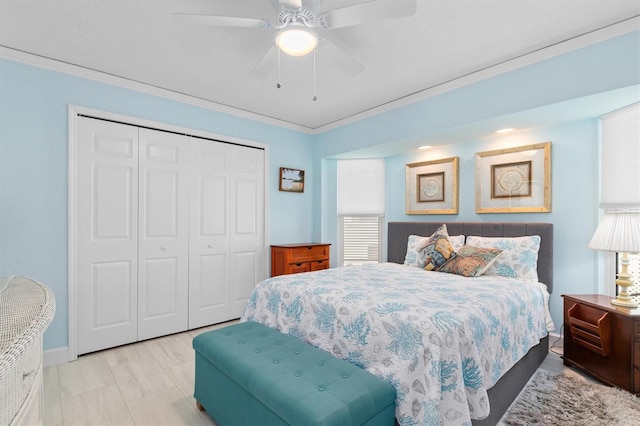 bedroom with ceiling fan, ornamental molding, and a closet