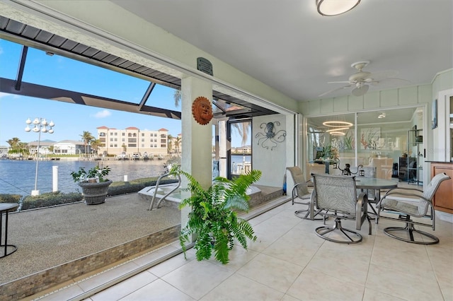 sunroom with a water view and ceiling fan