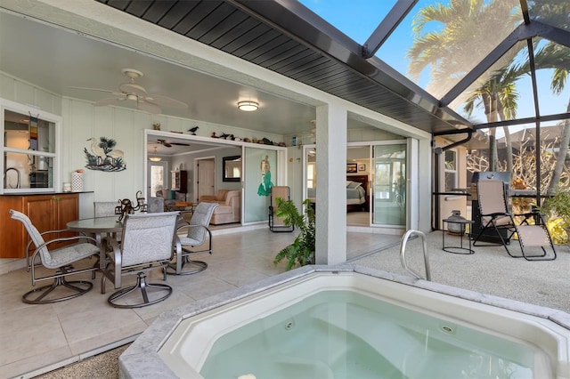 view of swimming pool with ceiling fan, a lanai, a jacuzzi, and a patio