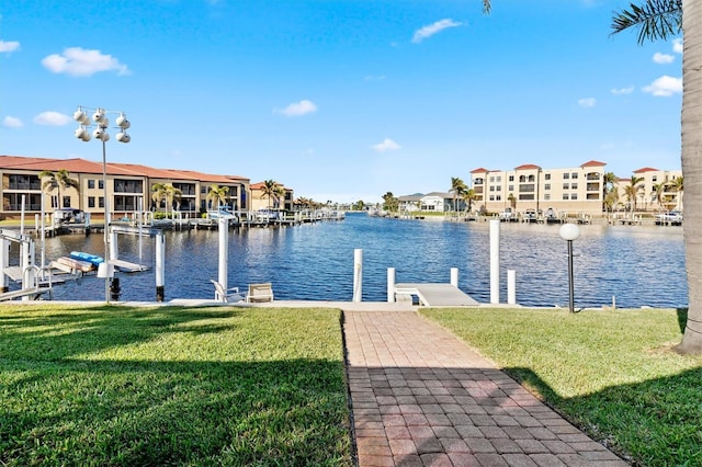 view of dock with a water view and a lawn