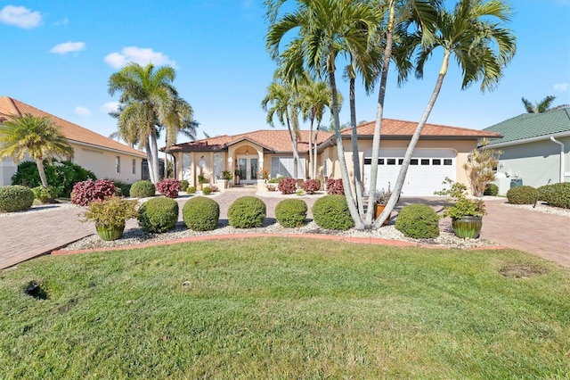 view of front of home with a garage and a front lawn