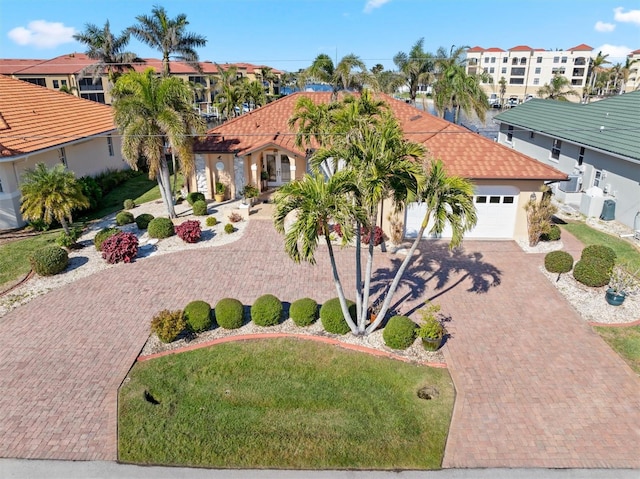 mediterranean / spanish house with a garage and a front yard