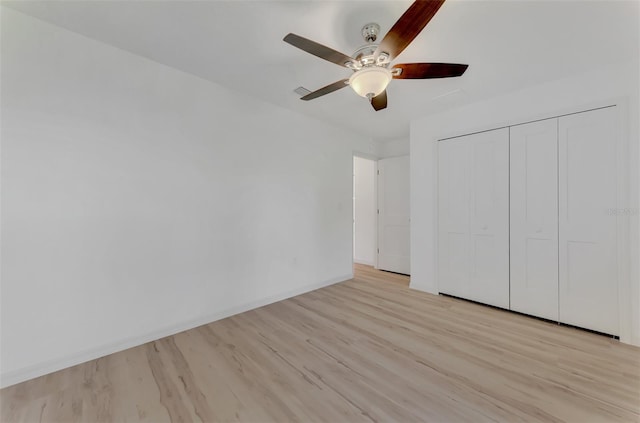 unfurnished bedroom with ceiling fan, light hardwood / wood-style floors, and a closet