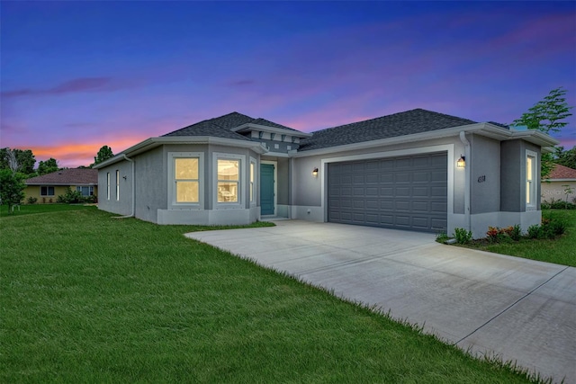 view of front of property featuring a garage and a lawn