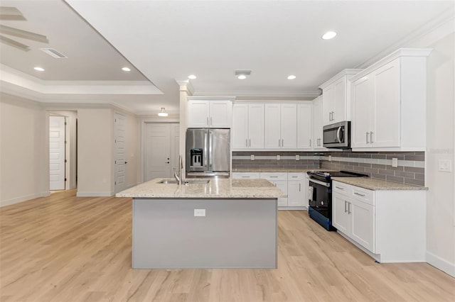 kitchen with sink, light stone counters, stainless steel appliances, a kitchen island with sink, and white cabinets