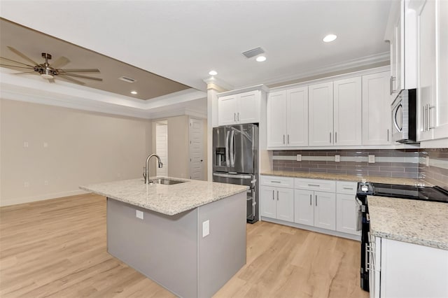 kitchen featuring sink, white cabinetry, tasteful backsplash, a center island with sink, and appliances with stainless steel finishes