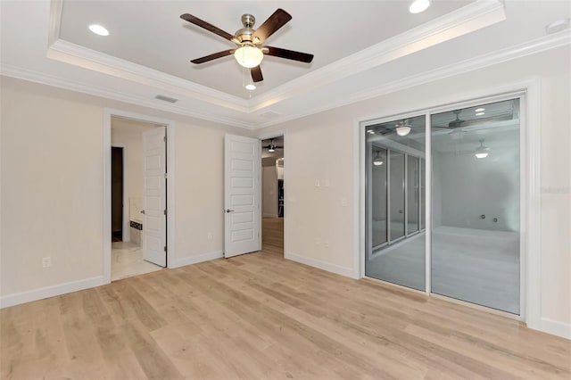 unfurnished bedroom featuring a tray ceiling, light hardwood / wood-style flooring, ornamental molding, and ceiling fan