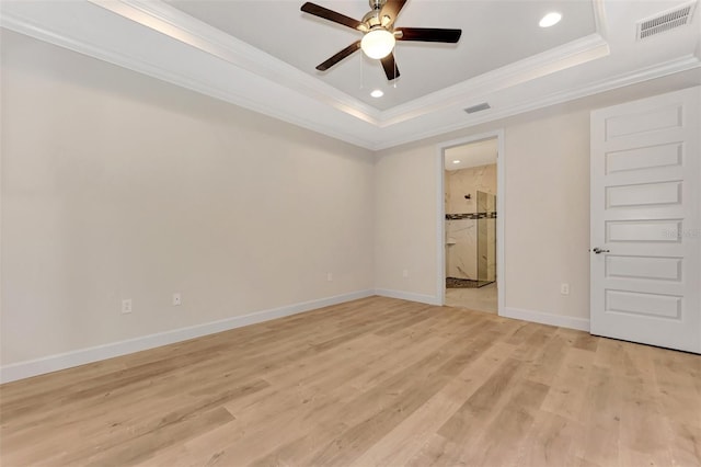 spare room featuring ceiling fan, ornamental molding, a raised ceiling, and light hardwood / wood-style flooring