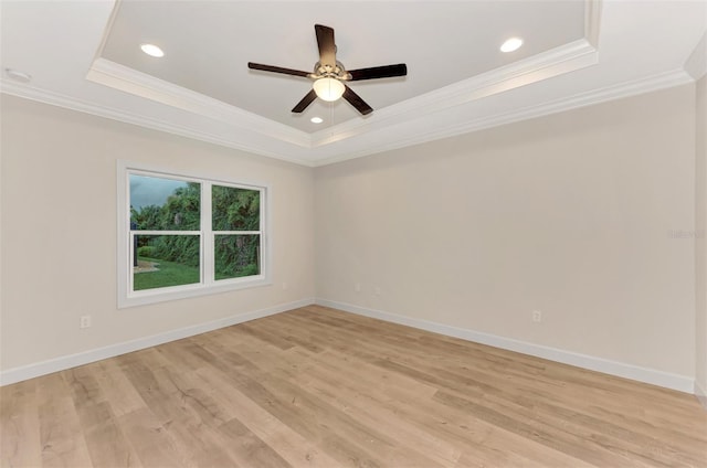 unfurnished room featuring crown molding, a tray ceiling, and light hardwood / wood-style flooring