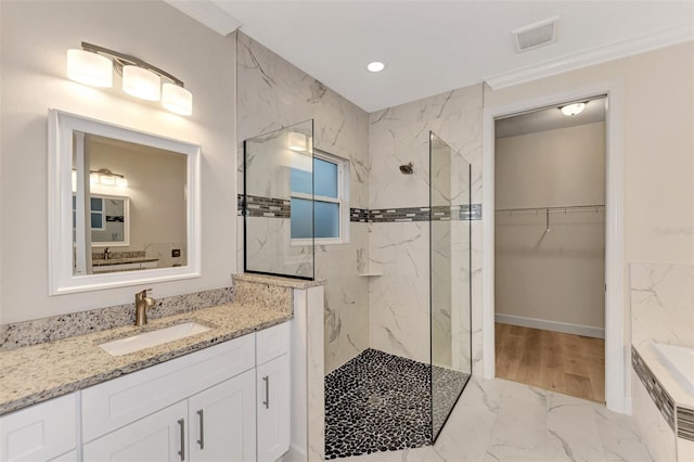 bathroom featuring ornamental molding, a tile shower, and vanity