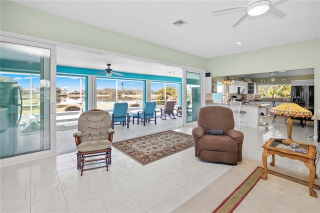 living room with ceiling fan with notable chandelier