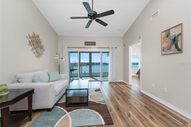 living room with lofted ceiling, hardwood / wood-style floors, and ceiling fan