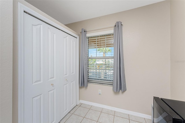 unfurnished bedroom featuring a closet and light tile patterned floors