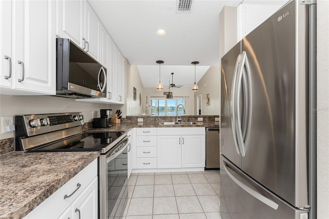 kitchen featuring sink, white cabinetry, light tile patterned floors, appliances with stainless steel finishes, and pendant lighting