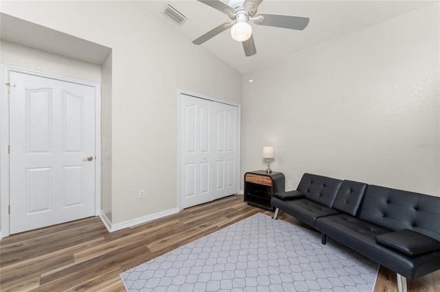 living room with hardwood / wood-style flooring, vaulted ceiling, and ceiling fan