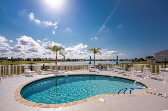 view of pool with a water view and a patio