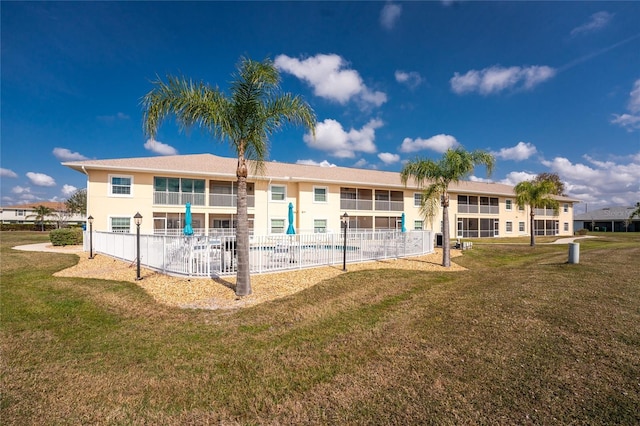 back of property featuring a pool and a yard