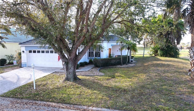 obstructed view of property with a garage and a front lawn