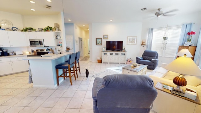 living room with ceiling fan and light tile patterned floors