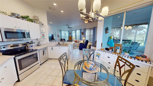 kitchen featuring light tile patterned flooring, sink, pendant lighting, stainless steel appliances, and white cabinets