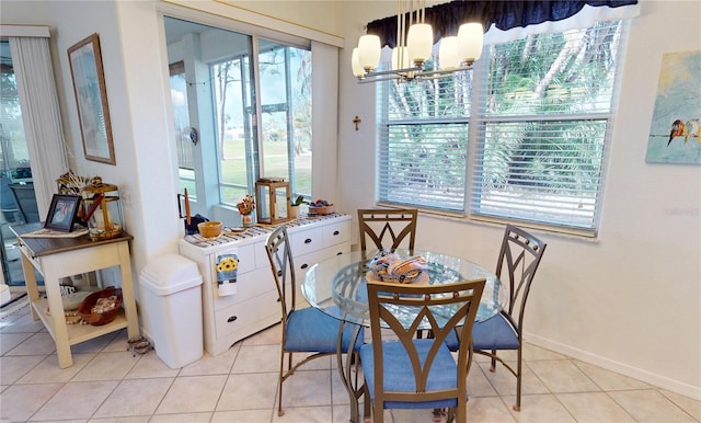 tiled dining space with a healthy amount of sunlight and a notable chandelier