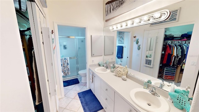 bathroom with vanity, toilet, an enclosed shower, and tile patterned flooring