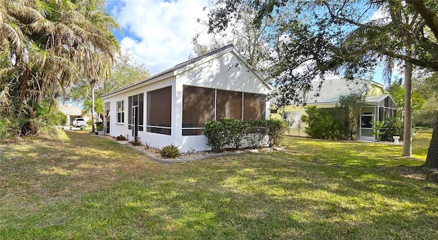 view of side of home with a yard and a sunroom