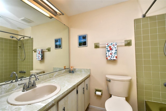 full bathroom featuring vanity, tiled shower / bath, and toilet