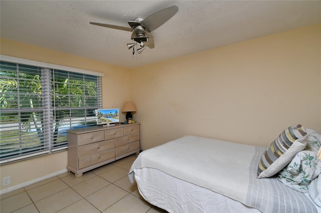 bedroom featuring light tile patterned floors, a textured ceiling, and ceiling fan