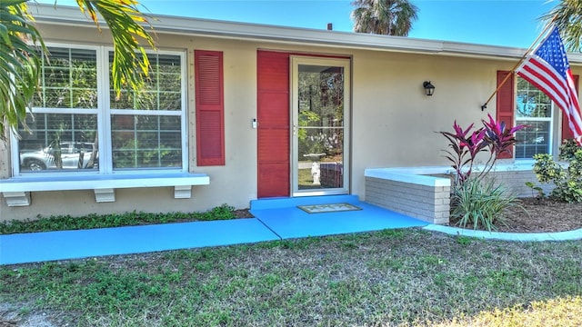 view of exterior entry featuring a yard