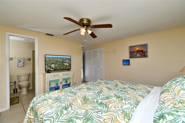 bedroom featuring connected bathroom, light tile patterned floors, a closet, and ceiling fan