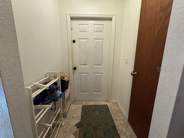 doorway to outside with light tile patterned flooring