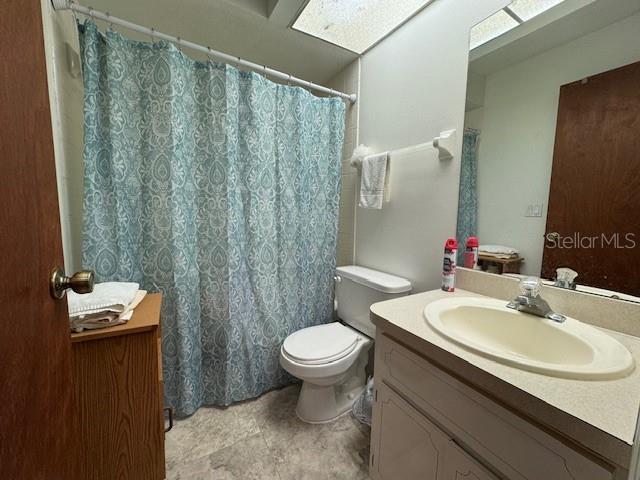 bathroom featuring vanity, toilet, and a skylight