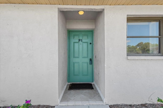 doorway to property featuring stucco siding