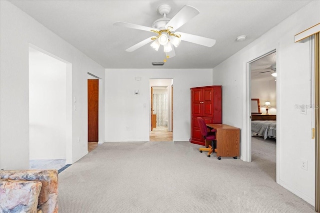 interior space featuring connected bathroom, visible vents, ceiling fan, and light carpet