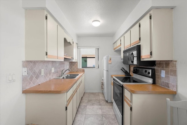 kitchen featuring backsplash, white cabinets, a sink, light tile patterned flooring, and white appliances