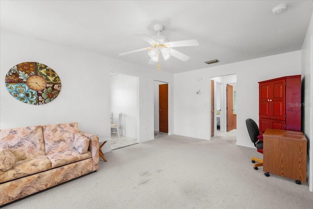 interior space featuring light colored carpet, visible vents, and ceiling fan