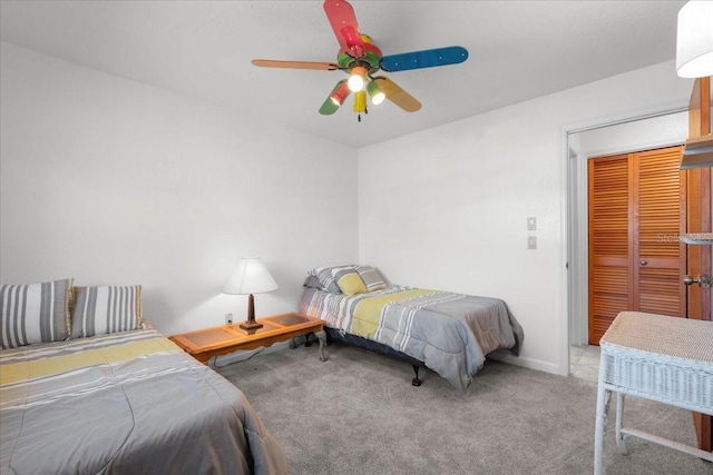 bedroom with a closet, light carpet, ceiling fan, and baseboards