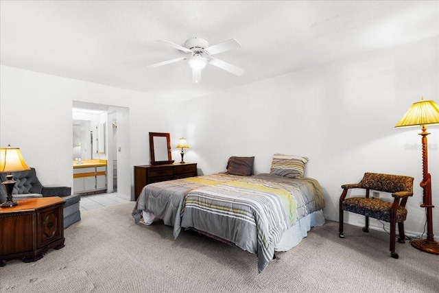 bedroom with light carpet, ceiling fan, and ensuite bath