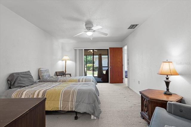 bedroom featuring light carpet, visible vents, a ceiling fan, a textured wall, and access to exterior