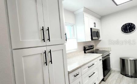 kitchen featuring light stone countertops, white cabinets, and appliances with stainless steel finishes