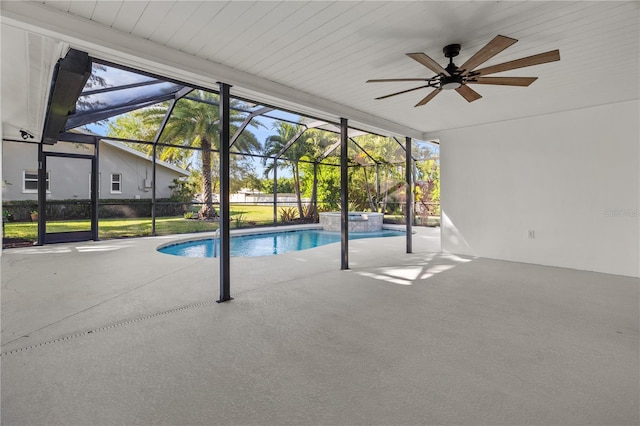 view of swimming pool with ceiling fan, a patio, a pool with connected hot tub, and glass enclosure