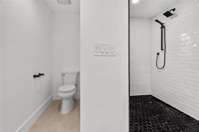 bathroom with visible vents, baseboards, toilet, tile patterned flooring, and a tile shower