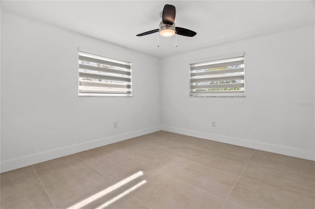 unfurnished room with ceiling fan and baseboards