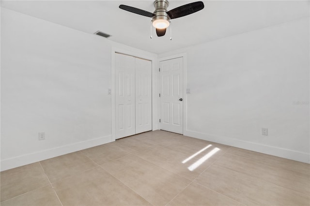 unfurnished bedroom featuring light tile patterned floors, baseboards, visible vents, and ceiling fan