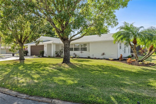 single story home featuring a garage, driveway, and a front lawn